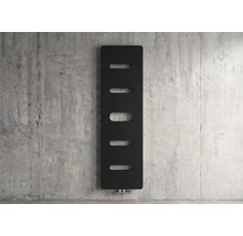Moderne verticale zwarte radiator met vijf ovale uitsparingen tegen een betonnen wand.