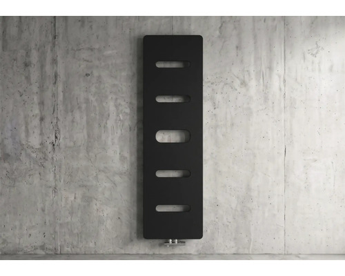 Moderne verticale zwarte radiator met vijf ovale uitsparingen tegen een betonnen wand.