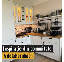Lichte L-vormige keuken met witte kasten, houten werkblad, achterwand van mozaïektegels en keukenapparatuur zoals een koffiezetapparaat.