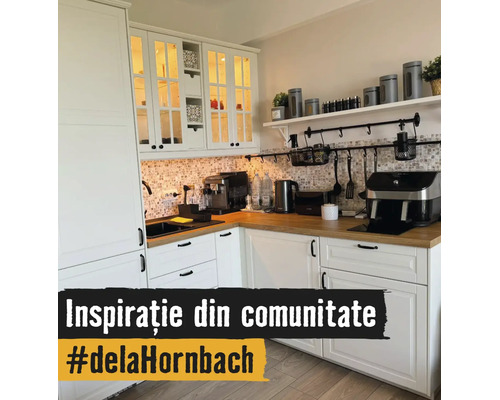 Lichte L-vormige keuken met witte kasten, houten werkblad, achterwand van mozaïektegels en keukenapparatuur zoals een koffiezetapparaat.