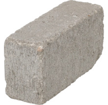 Een enkele rechthoekige betonsteen met een ruw oppervlak voor metselwerk.