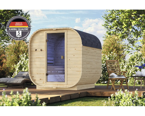 Houten buitensauna met een ovale vorm en een glazen deur op een houten terras in de tuin, inclusief Karibu kwaliteits- en garantie-zegel.
