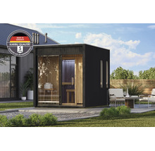 Moderne Karibu tuinsauna met glazen pui en houten interieur in een verzorgde tuin met zitgedeelte.