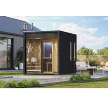 Moderne houten buitensauna met grote glazen pui en donker frame in een tuin naast een terras met zitmeubels.