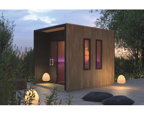 Moderne tuinsauna met verticale houten lattengevel en twee smalle ramen op een houten terras in de tuin.