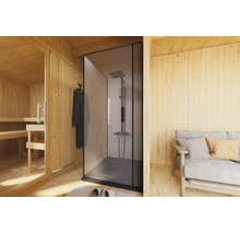 Moderne douche met glazen douchewand en regendouche in een wellnessruimte met houten sauna en zithoek.