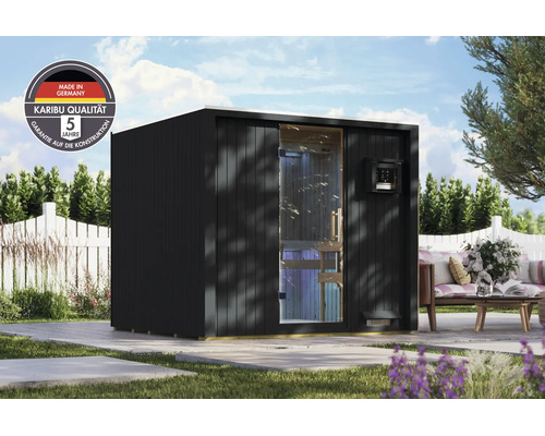 Moderne Karibu tuinsauna met glazen voorzijde en plat dak in een tuin met zitgedeelte en vijf jaar garantie op de constructie.