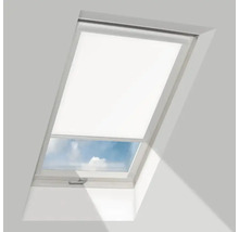 Wit dakraam met half neergelaten rolgordijn en zicht op de lucht.
