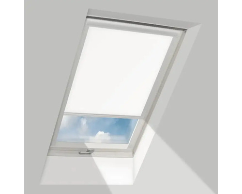 Wit dakraam met half neergelaten rolgordijn en zicht op de lucht.
