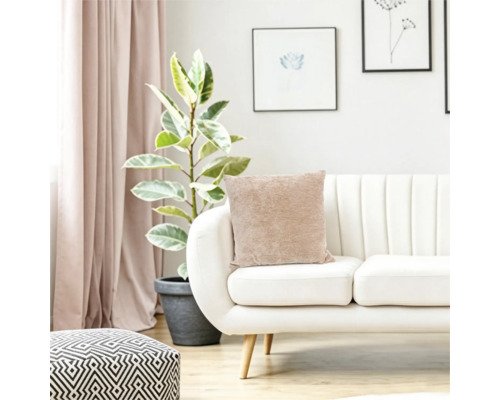 Woonkamer met modern bankstel, beige kussen, kamerplant en geometrische poef in een licht en gezellig interieur.