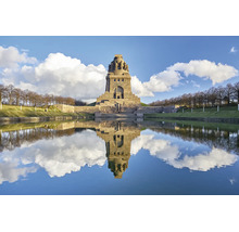Het Monument van de Volkerenslag in Leipzig weerspiegelt in het waterbekken voor het monumentale stenen bouwwerk bij zonnig weer.