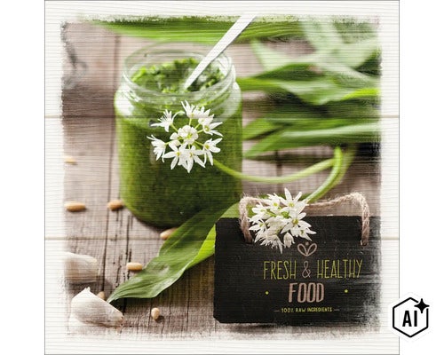 Daslookpesto in een pot met verse daslookbloemen en een bordje met de tekst Vers en gezond op een houten ondergrond. (Image AI modified or generated)