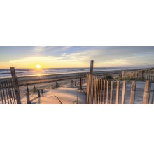 Strand met houten hek bij zonsondergang