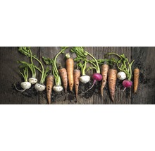 Diverse soorten vers geoogste wortelgroenten op een houten tafel.