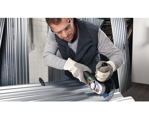 Man snijdt een plaat metaal met een haakse slijper