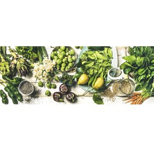 Verse groenten op een witte achtergrond, waaronder artisjokken, spruitjes, groene paprika's, spinazie en wortelen.