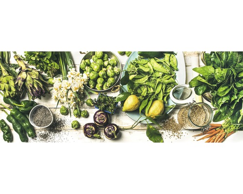 Verse groenten op een witte achtergrond, waaronder artisjokken, spruitjes, groene paprika's, spinazie en wortelen.