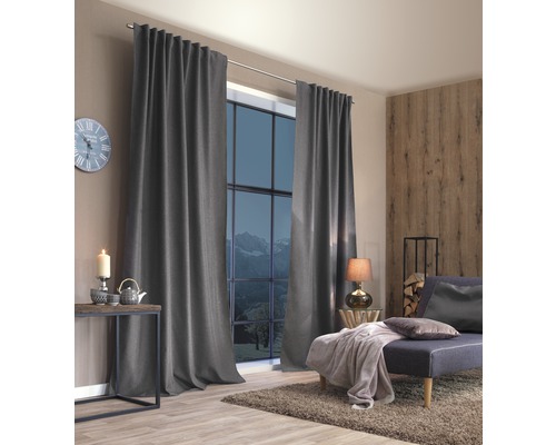 Woonkamer met grijze gordijnen, bank en houten elementen
