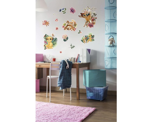 Decoratieve kinderkamer met muurstickers van Disney''s Bambi en De Leeuwenkoning boven een bureau.
