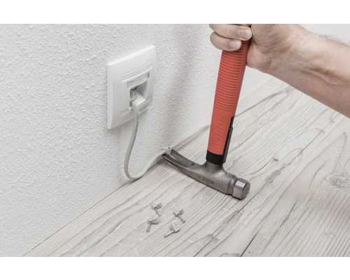Installatie van een netwerkkabel met een hamer en kabelklemmen.