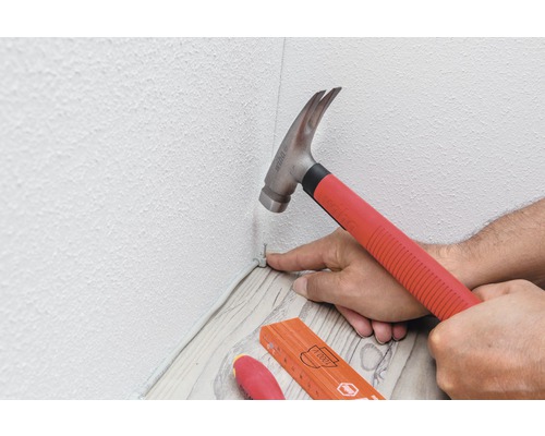 Bevestigen van een plint met hamer en spijker