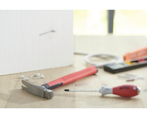 Hamer, schroevendraaier, waterpas en spijkers op een houten vloer