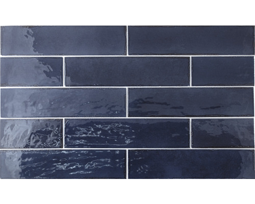 Blauwe glanzende rechthoekige tegels zijn op een muur geplaatst.