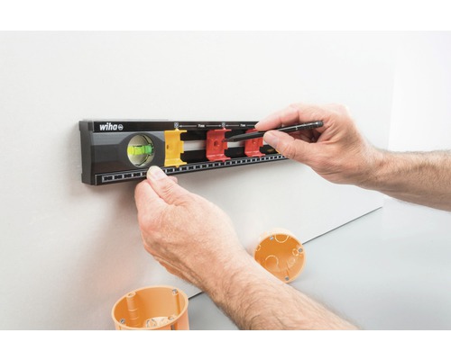 Wiha Logo. Muurmontage met waterpas en potlood om boorgaten te markeren.