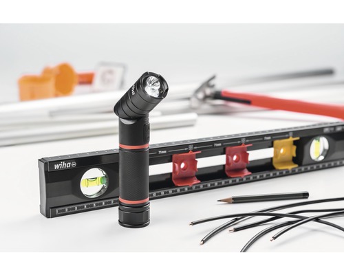 Wiha logo, waterpas, werklamp en elektriciteitskabels op een heldere achtergrond