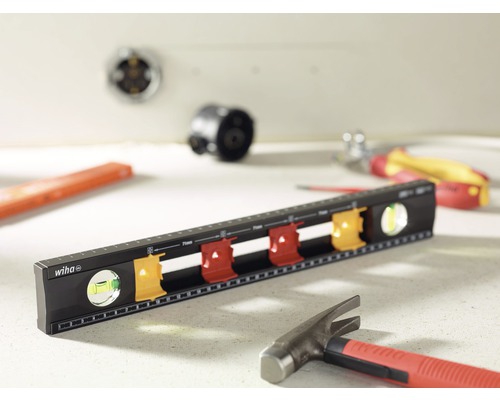 Waterpas van het merk Wiha met diverse gereedschappen op de achtergrond