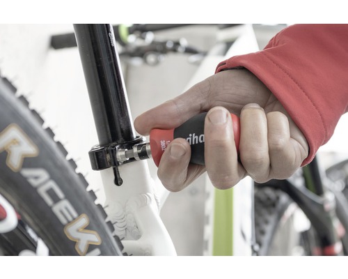 Een man gebruikt een Wiha schroevendraaier op een fiets.