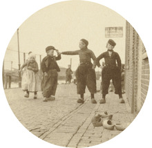 Historische foto van kinderen in traditionele Nederlandse kleding en klompen