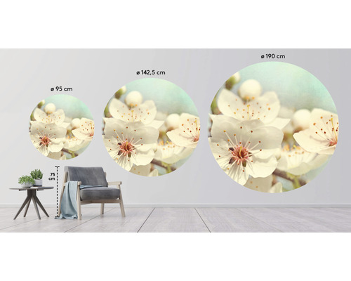 Drie ronde muurschilderingen met bloemmotieven in verschillende maten boven een fauteuil en een tafel.