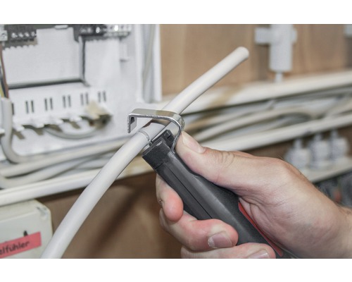 Een persoon verwijdert de isolatie van een kabel met een kabelmes.