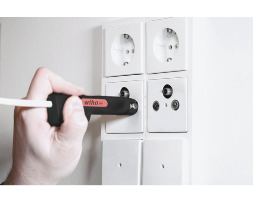 Hand met Wiha schroevendraaier bij antenneaansluitdoos