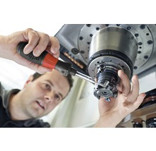 Een man gebruikt precisiegereedschap op een werktuigmachine.