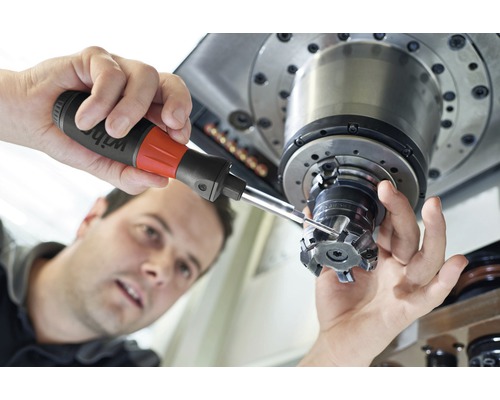 Een man gebruikt precisiegereedschap op een werktuigmachine.