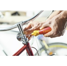 Een persoon repareert een fiets met een schroevendraaier.
