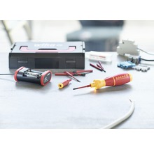 Wiha gereedschapsset met schroevendraaiers, oplader en accessoires op een werkbank.