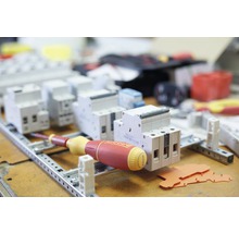 Rij van miniatuurstroomonderbrekers op een montagerail met schroevendraaier