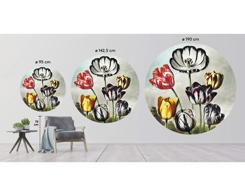Decoratieve muurafbeelding met bloemmotief in drie verschillende maten naast een fauteuil en een tafel