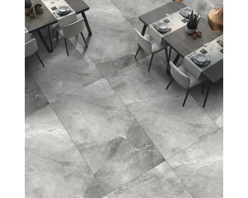 Grootformaat vloertegels met marmerlook in een eetkamer met tafels en stoelen.