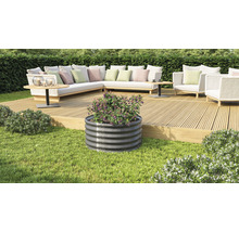 Metalen plantenbak met beplanting in de tuin