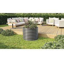 Metalen plantenbak met beplanting op een terras met tuinmeubilair