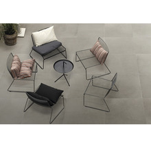 Groep zwarte metalen stoelen met kussens en een kleine tafel