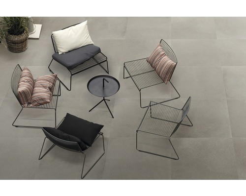 Groep zwarte metalen stoelen met kussens en een kleine tafel