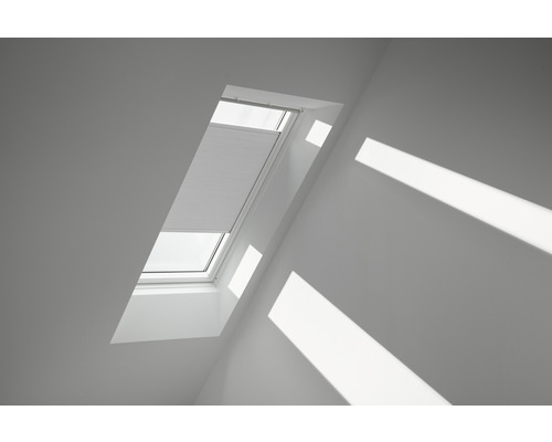 VELUX Plissé honingraat verduisterend handbediend FHC C02 1045SWL wit Dakvenster met gedeeltelijk gesloten plissé in een zolderkamer.