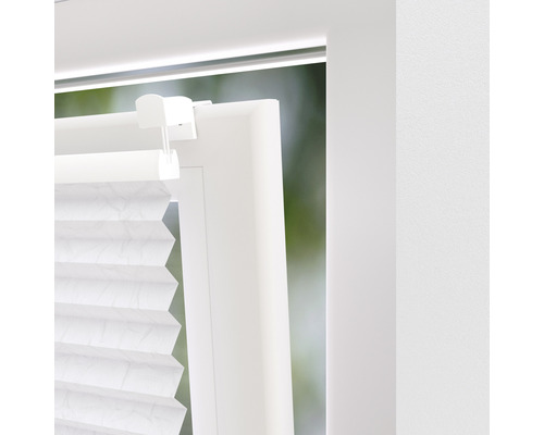 Detail van een wit plisségordijn op een raam