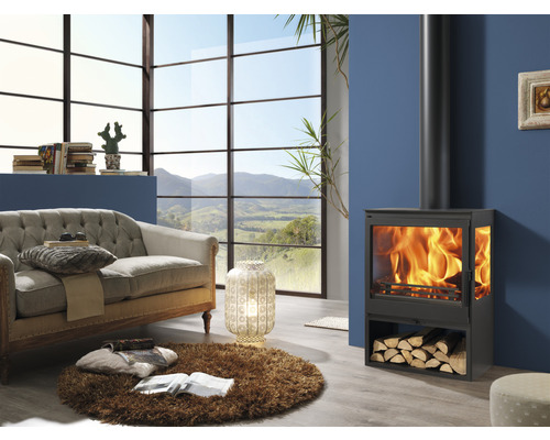 Woonkamer met houtkachel, bank en groot raam met uitzicht