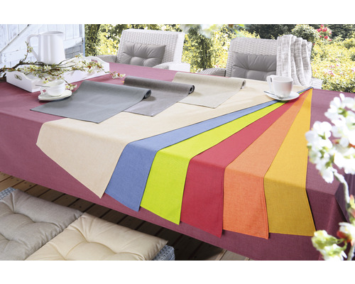 Tafeldecoratie met tafelkleden in diverse kleuren op een gedekte tafel buitenshuis.